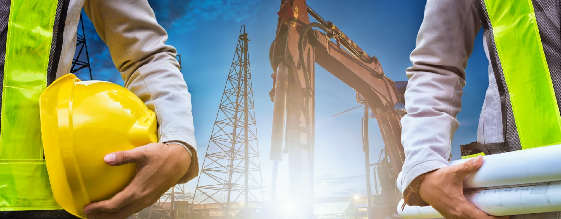 Osoby w kamizelkach odblaskowych na tle dźwigu budowlanego